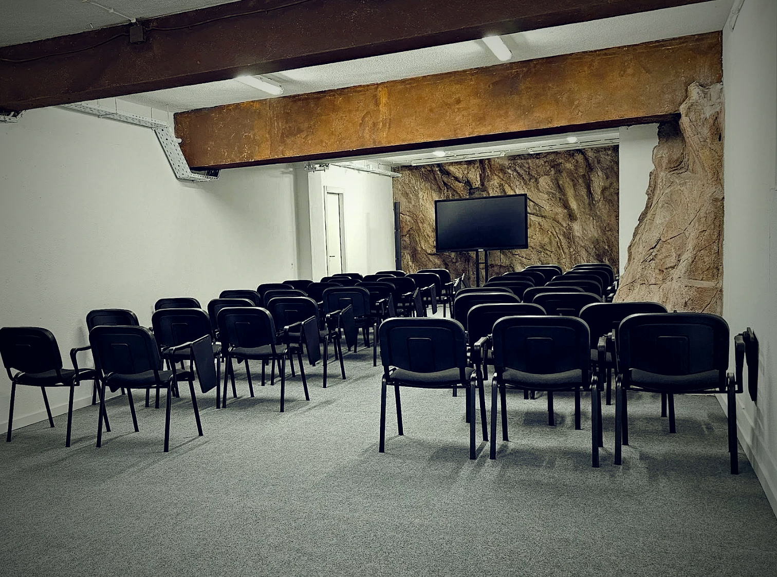 Sala do evento no espaço IDN — 50 cadeiras e ecrã de palestra